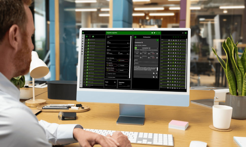 Foto di un impiegato alla scrivania di spalle e davanti a lui uno schermo di un computer che mostra la dashboard di una delle app custom che sviluppiamo.