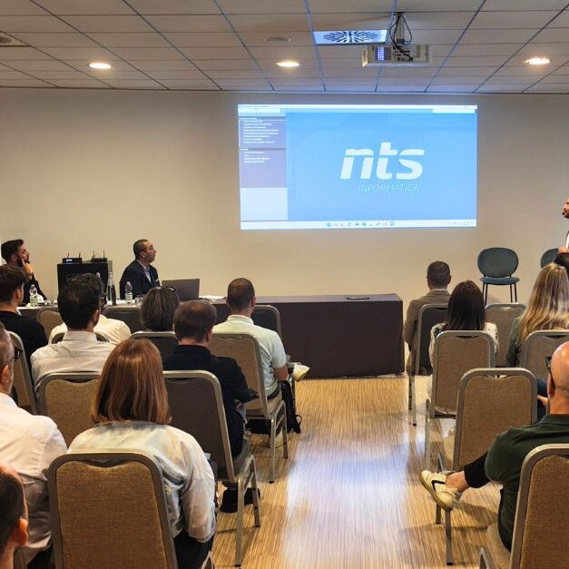 Intervento tecnico durante l’evento Generazione AI, con pubblico in sala e slide proiettata da NTS Informatica.