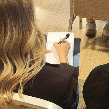 Partecipante prende appunti durante l’evento Generazione AI, seguendo una sessione dedicata all’intelligenza artificiale.